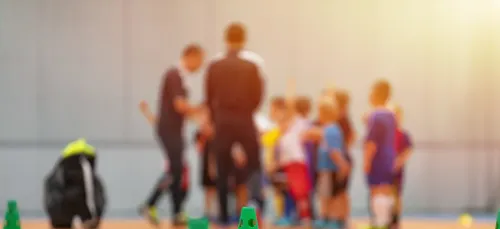 group of kids with a trainer listening to his speech